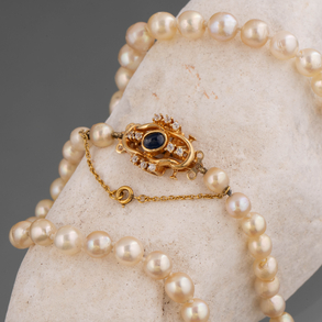 Collar de perlas cultivadas con cierre en oro amarillo de 18 kt con zafiro en cabujón.