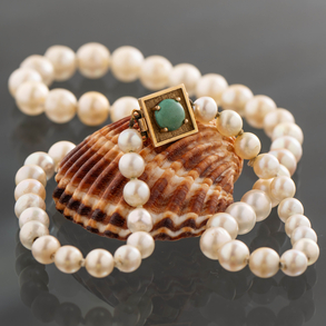 0,5 cms cultured pearl necklace with 18kt yellow gold clasp and turquoise stone in the centre.