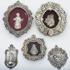 Conjunto de tres relicarios, medallas y aguabendietra en plata española del siglo XX.